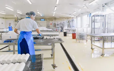 위생복 차림 작업자가 일하는 청결한 식품 공장 — HACCP 인증