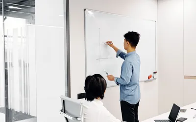 화이트보드 앞 경영 전략 회의 — 메인비즈(경영혁신형 중소기업) 선정